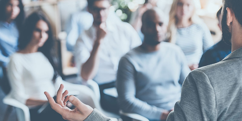 Man talking to room full of people