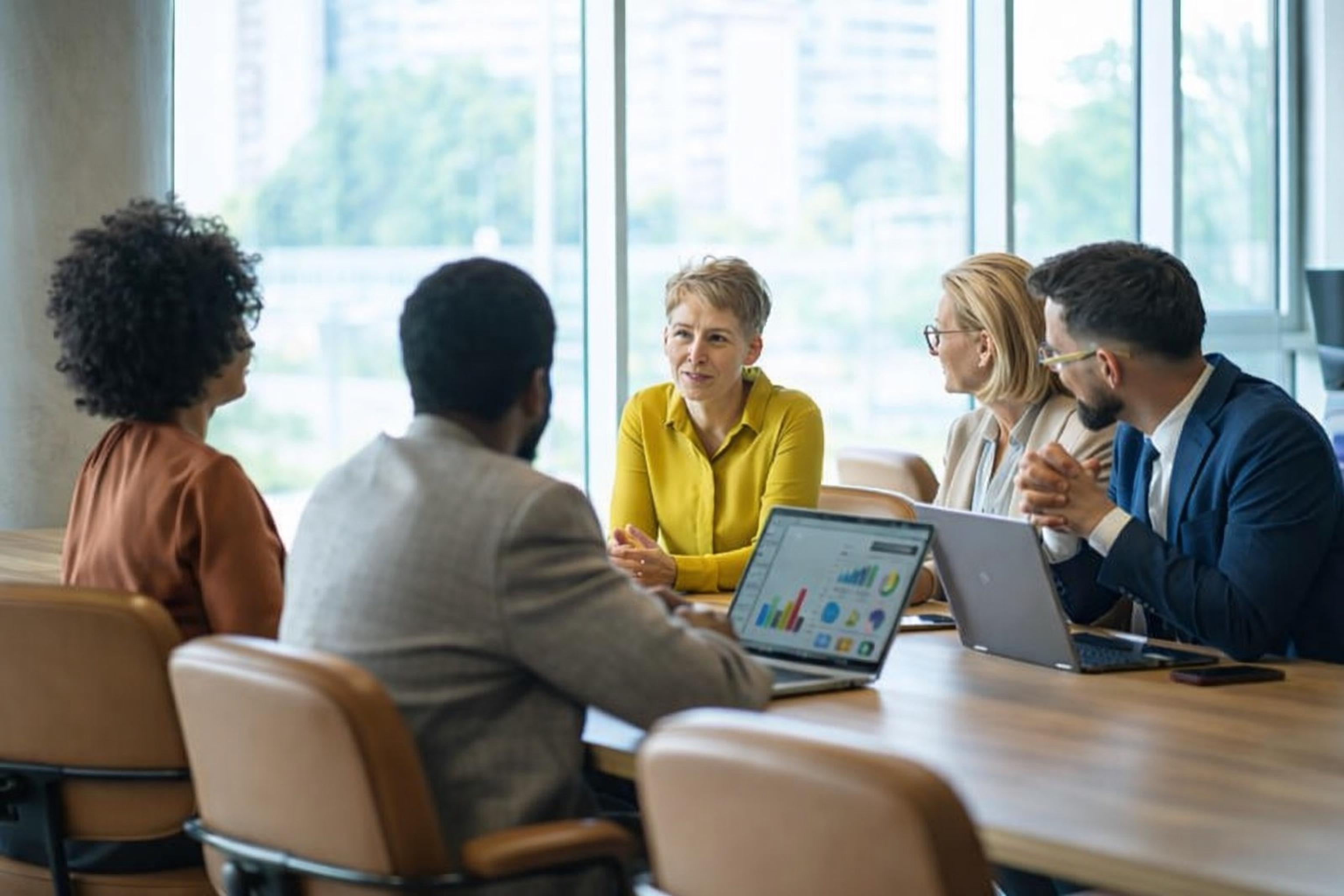 Sales manager leading a team huddle in a modern office environment
